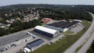 Padelhallen Padelroom Bollebygd ute från sidan. Grå tälthall med vitt tak